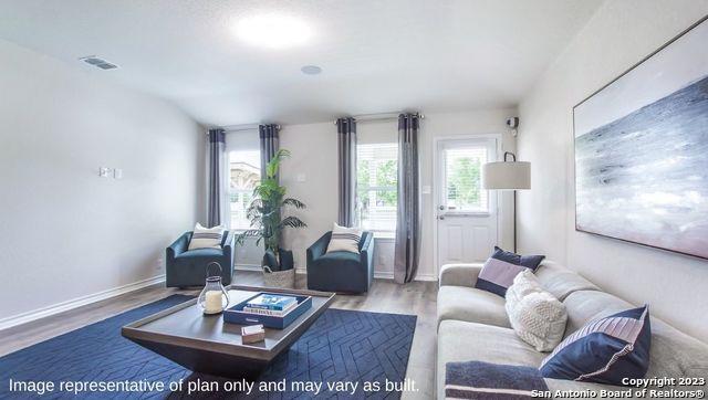 living area featuring wood finished floors, visible vents, and baseboards