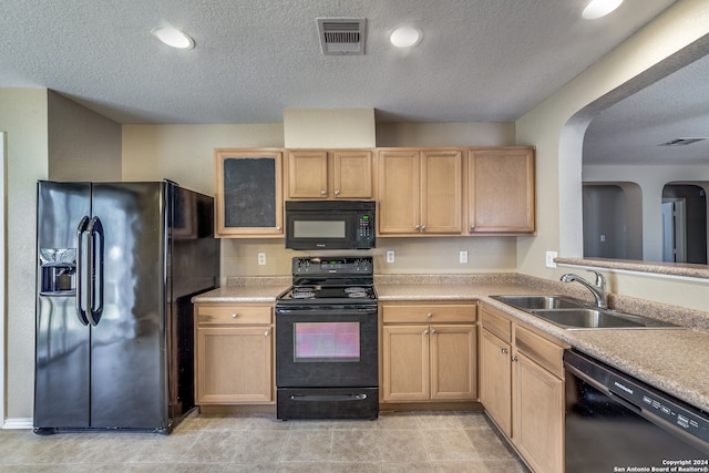 kitchen with light tile patterned floors, light brown cabinets, sink, and black appliances