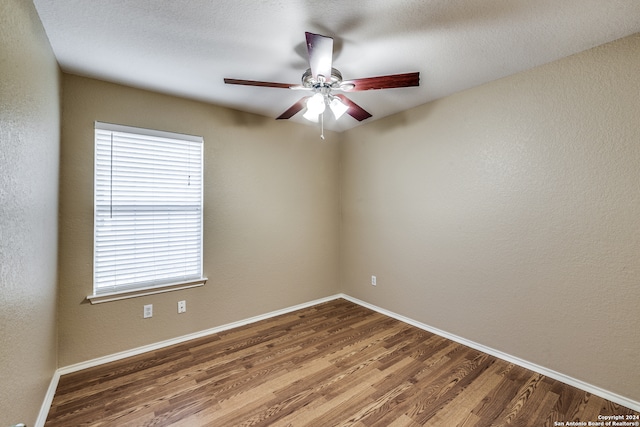 empty room featuring ceiling fan, hardwood / wood-style flooring, and a textured ceiling