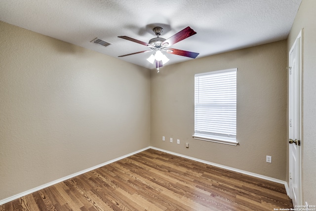 unfurnished room featuring ceiling fan, wood-type flooring, and a textured ceiling