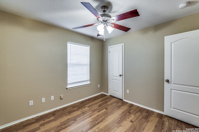 unfurnished bedroom featuring ceiling fan, hardwood / wood-style floors, and a textured ceiling