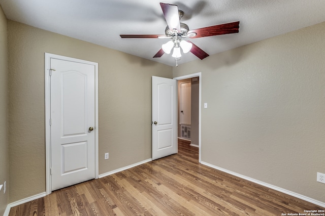 unfurnished bedroom with ceiling fan and hardwood / wood-style floors