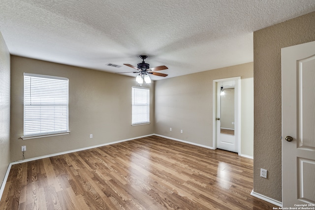 empty room with wood-type flooring, a textured ceiling, and ceiling fan