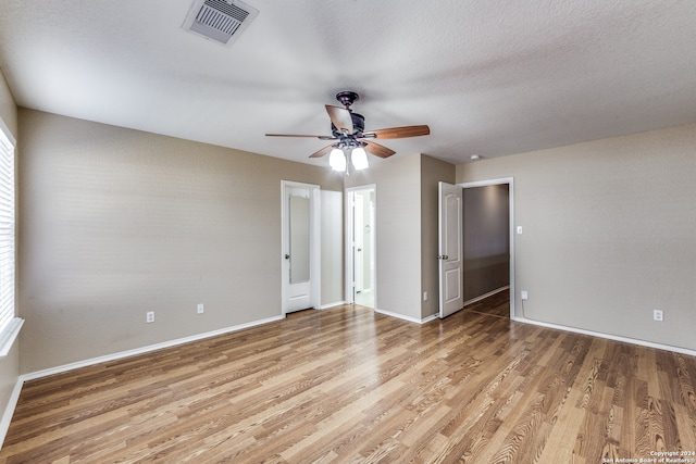 spare room with ceiling fan, a textured ceiling, and light hardwood / wood-style floors