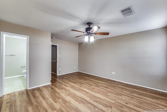 unfurnished room with hardwood / wood-style flooring, a textured ceiling, and ceiling fan