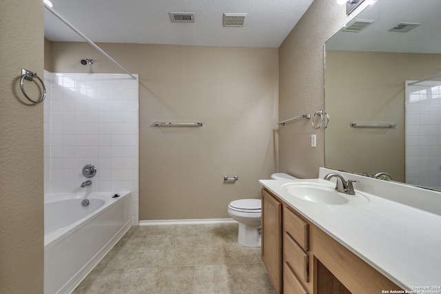 full bathroom featuring toilet, tile patterned floors, tiled shower / bath, vanity, and a textured ceiling