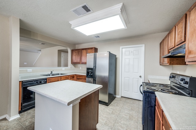 kitchen with a kitchen island, black appliances, sink, and a textured ceiling