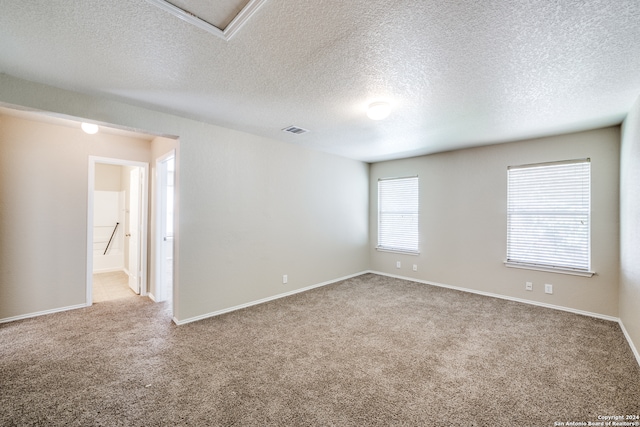 carpeted empty room featuring a textured ceiling