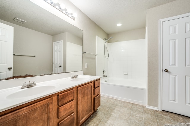 bathroom with vanity, a textured ceiling, tile patterned flooring, and shower / washtub combination