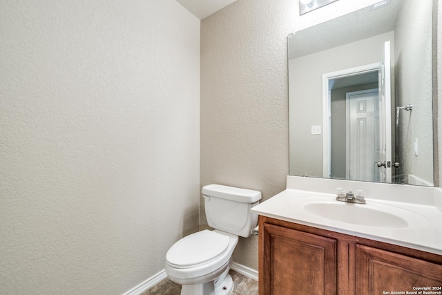2815 Bandbury Oak, San Antonio, TX 78247 - bathroom featuring toilet, vanity, a textured wall, and baseboards
