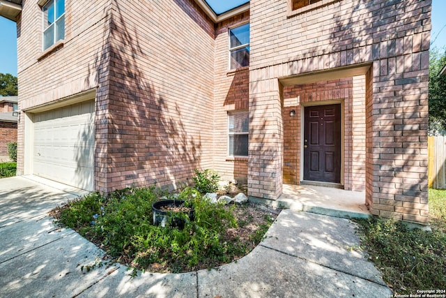 2815 Bandbury Oak, San Antonio, TX 78247 - view of exterior entry with brick siding, an attached garage, and driveway