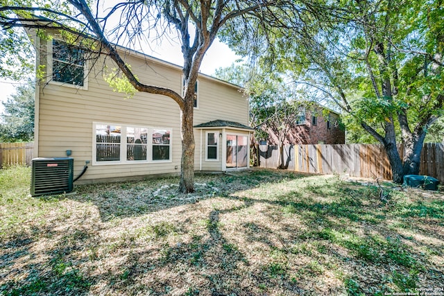 back of house featuring a yard and central AC