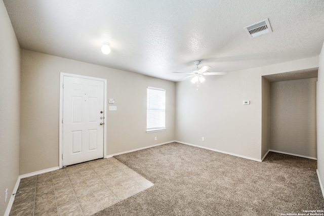 carpeted spare room with ceiling fan and a textured ceiling