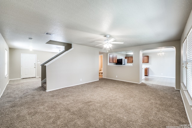 unfurnished living room with ceiling fan, carpet, and a textured ceiling