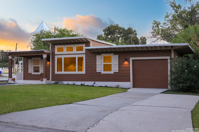 view of front of property featuring a yard and a garage