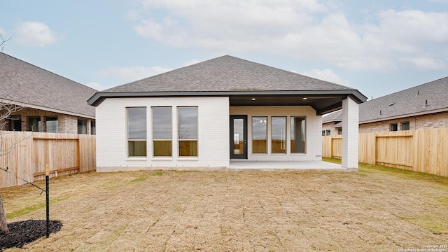 rear view of house with a lawn and a patio area