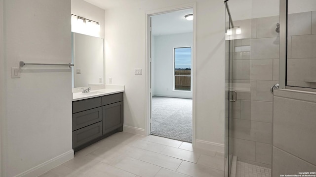 bathroom featuring vanity, a shower with shower door, and tile patterned floors