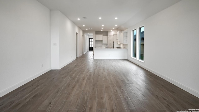 unfurnished living room with dark hardwood / wood-style flooring and sink