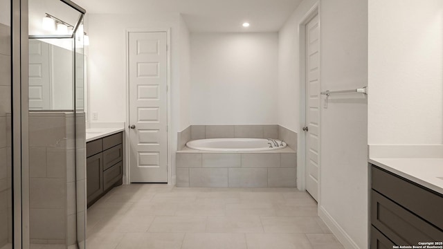 bathroom with vanity, tile patterned floors, and shower with separate bathtub