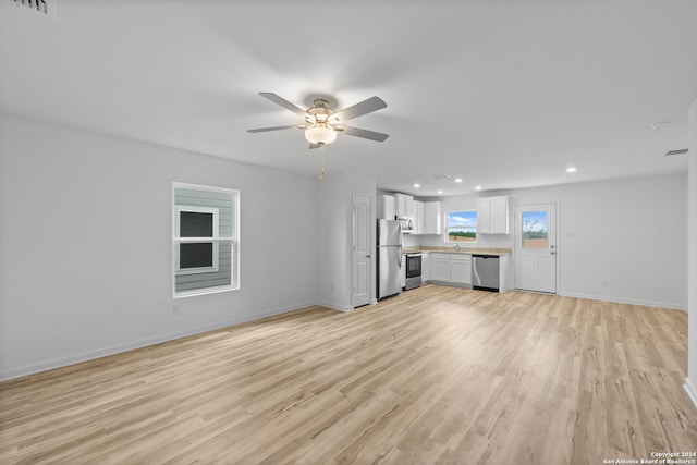 unfurnished living room featuring light wood-type flooring and ceiling fan