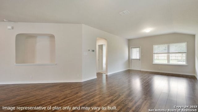 empty room with lofted ceiling and dark hardwood / wood-style floors