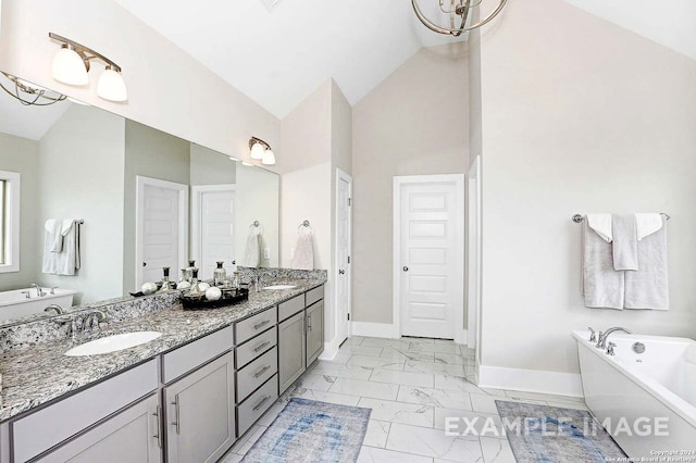 bathroom featuring lofted ceiling, a bath, and vanity