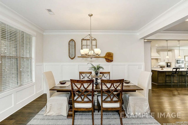 dining space featuring dark wood-style floors, visible vents, a notable chandelier, crown molding, and a decorative wall