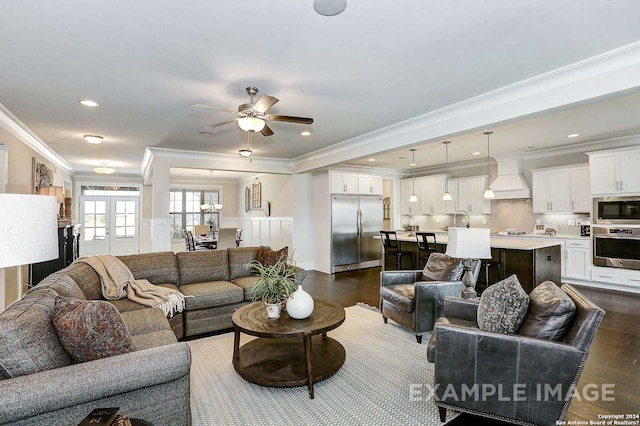 living room featuring ceiling fan, sink, crown molding, and dark hardwood / wood-style flooring