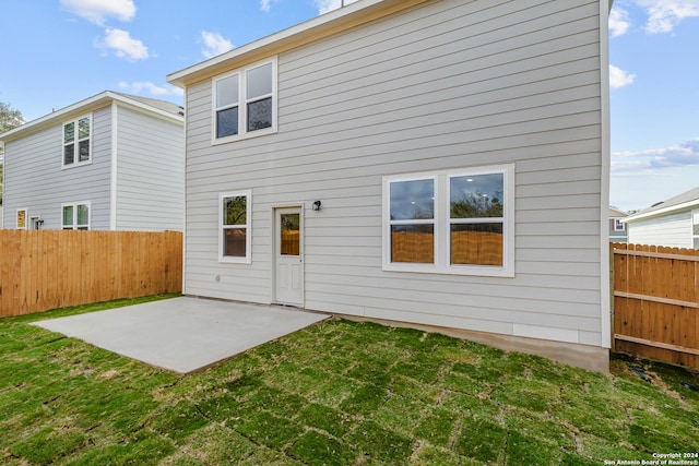 rear view of house with a lawn and a patio area