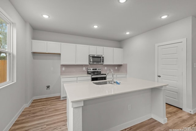 kitchen featuring white cabinets, sink, an island with sink, and appliances with stainless steel finishes