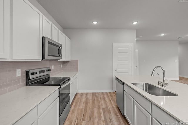 kitchen featuring white cabinetry, sink, light wood-type flooring, and stainless steel appliances