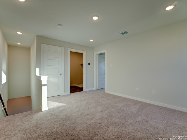 unfurnished bedroom with light carpet, a walk in closet, and a closet