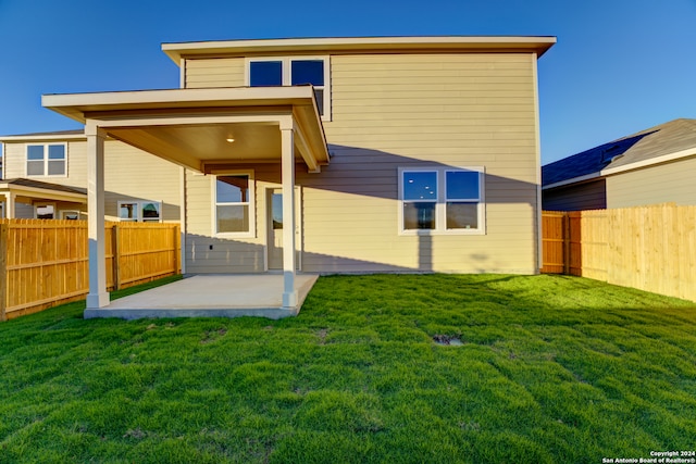 back of house with a patio area and a yard