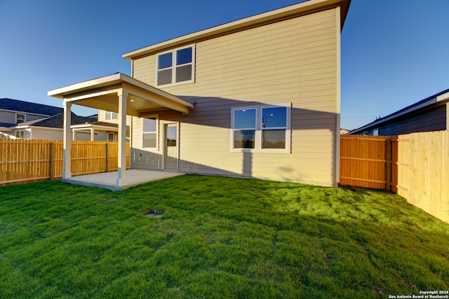 rear view of property featuring a yard and a patio