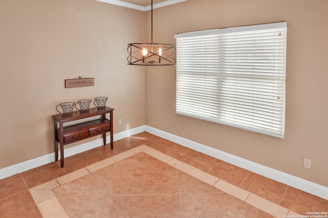 dining space with crown molding, a chandelier, and tile patterned flooring