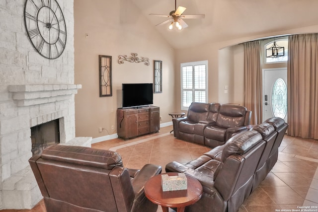 tiled living room featuring high vaulted ceiling, a fireplace, and ceiling fan