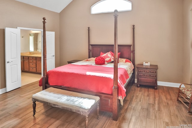 bedroom featuring sink, ensuite bath, vaulted ceiling, and light hardwood / wood-style flooring