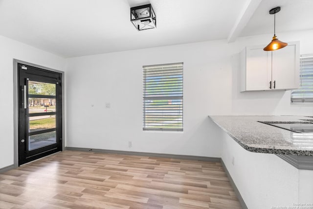 214 Oriole, San Antonio, TX 78228 - unfurnished dining area with beamed ceiling, baseboards, and light wood-style floors