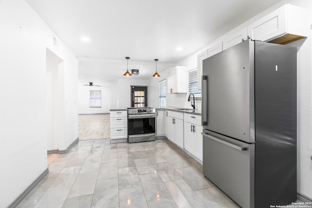 kitchen featuring white cabinets, appliances with stainless steel finishes, hanging light fixtures, and sink