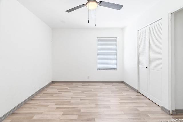 214 Oriole, San Antonio, TX 78228 - unfurnished bedroom featuring a closet, baseboards, a ceiling fan, and light wood-type flooring