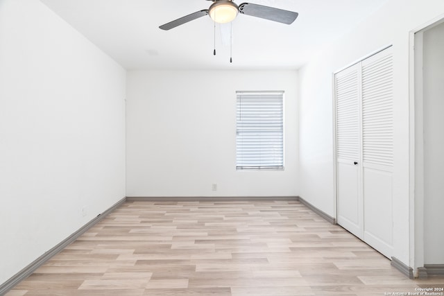 unfurnished bedroom featuring ceiling fan, a closet, and light hardwood / wood-style floors