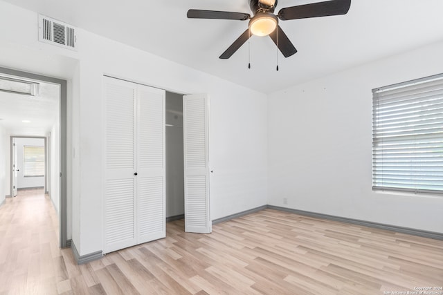 unfurnished bedroom with light wood-type flooring, multiple windows, and ceiling fan