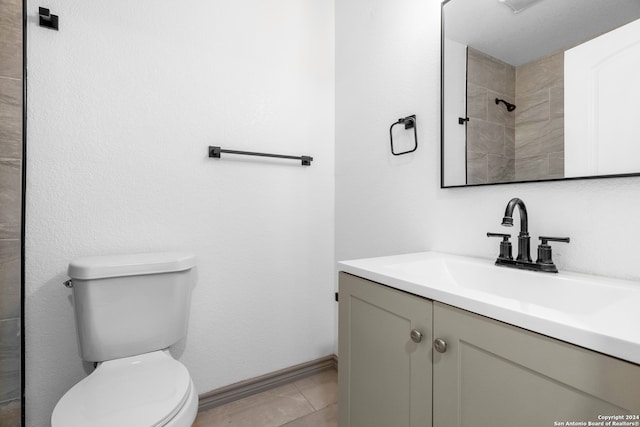 bathroom featuring vanity, tile patterned flooring, toilet, and walk in shower