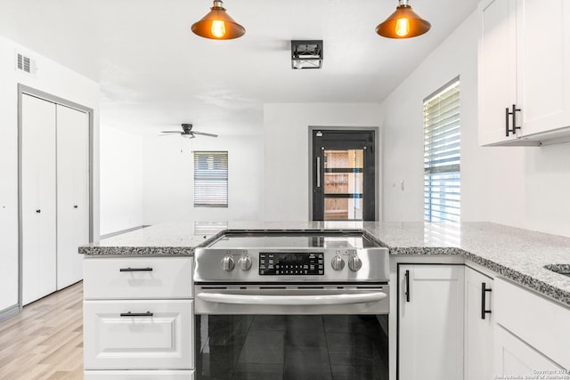 214 Oriole, San Antonio, TX 78228 - kitchen featuring visible vents, stainless steel electric range, light stone counters, a peninsula, and white cabinetry