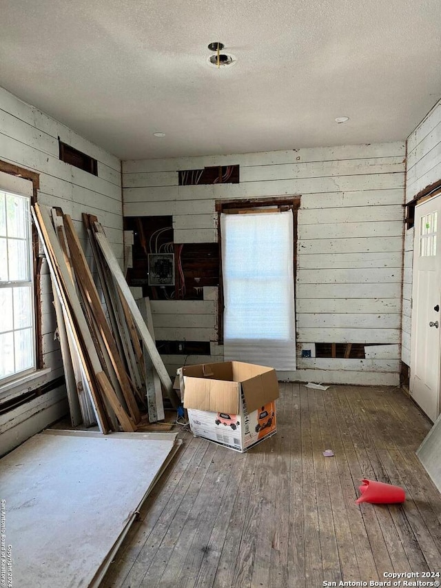 interior space with wood walls, hardwood / wood-style flooring, and a textured ceiling