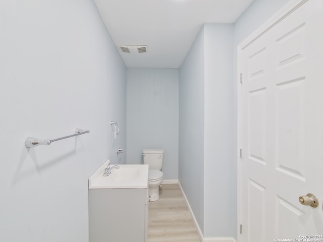 bathroom featuring vanity, hardwood / wood-style floors, and toilet