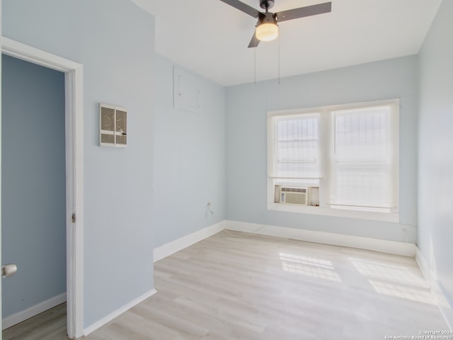 spare room featuring ceiling fan, cooling unit, and light wood-type flooring