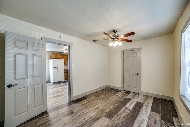 empty room with ceiling fan, a textured ceiling, and hardwood / wood-style floors