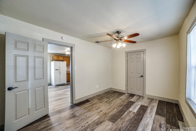 unfurnished room with visible vents, baseboards, ceiling fan, a textured ceiling, and wood finished floors