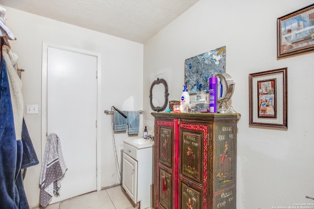 interior space with vanity, a textured ceiling, and tile patterned flooring